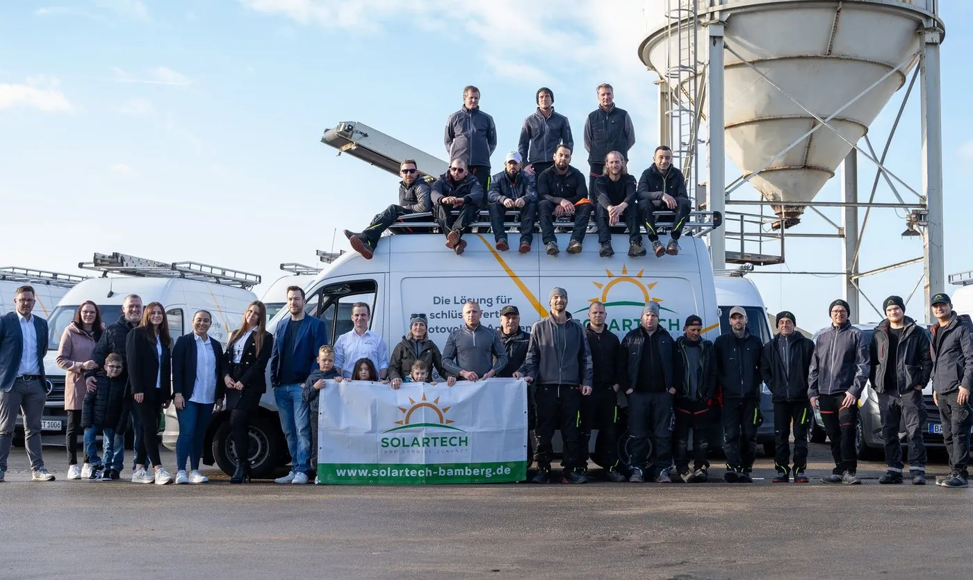 Die Mannschaft von Solartech vor den Firmenfahrzeugen